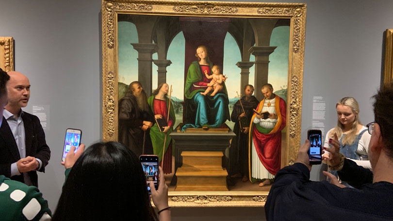 With Associate Professor of Art History Nicola Camerlenghi, left, students test out the new Augmented Dartmouth app on Perugino's Virgin and Child with Saints in the Hood Museum of Art.